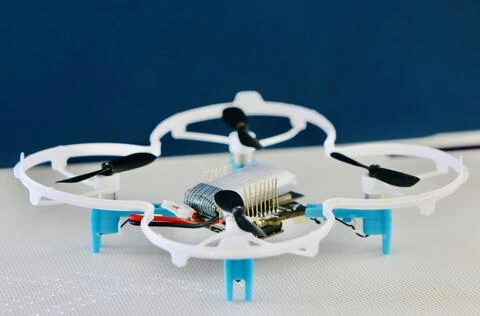 Xfly quadcopter with prop guards and an exposed flight controller, resting on a mat